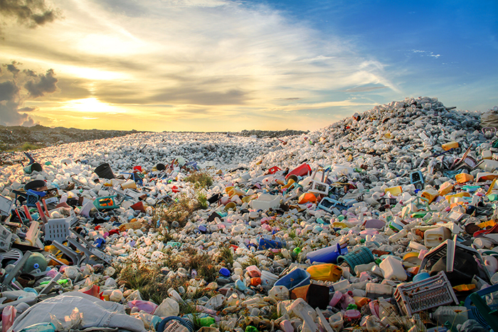 Müllhalde mit Plastikabfällen bei Sonnenuntergang Ein Sonnenuntergang über einer großen Ansammlung von Plastikabfällen auf einer Müllhalde