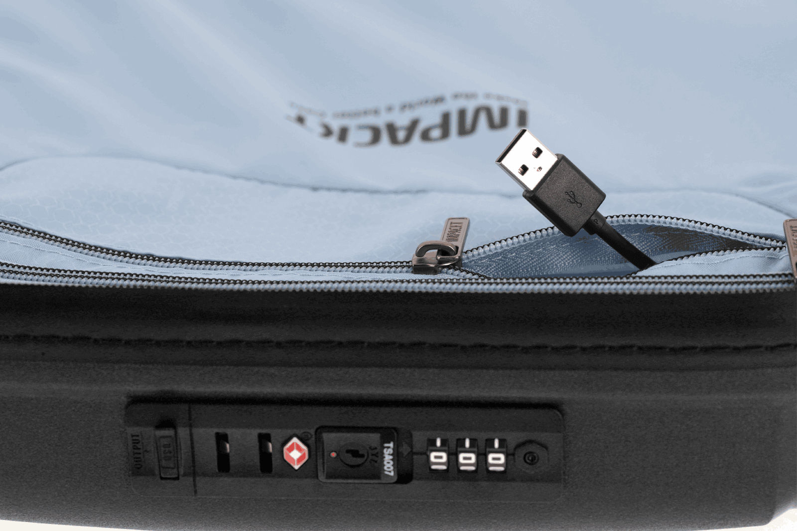 USB-Anschluss an einem hellblauen Koffer mit TSA-Schloss Nahaufnahme eines USB-Anschlusses und TSA-Schlosses an einem hellblauen Koffer