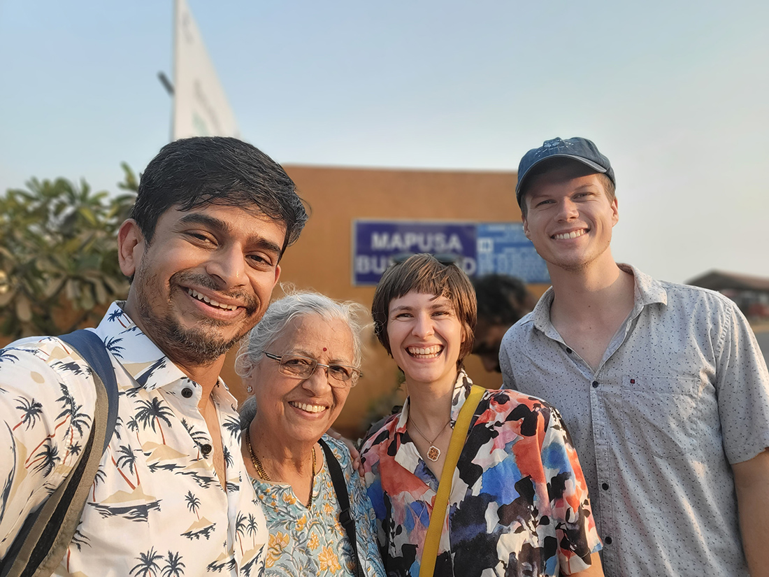 Indien für Anfänger:innen: 5 nachhaltige Reisetipps für die Küstenregion Goa Vier lachende Personen stehen nebeneinander im Freien, gut gelaunt bei sonnigem Wetter