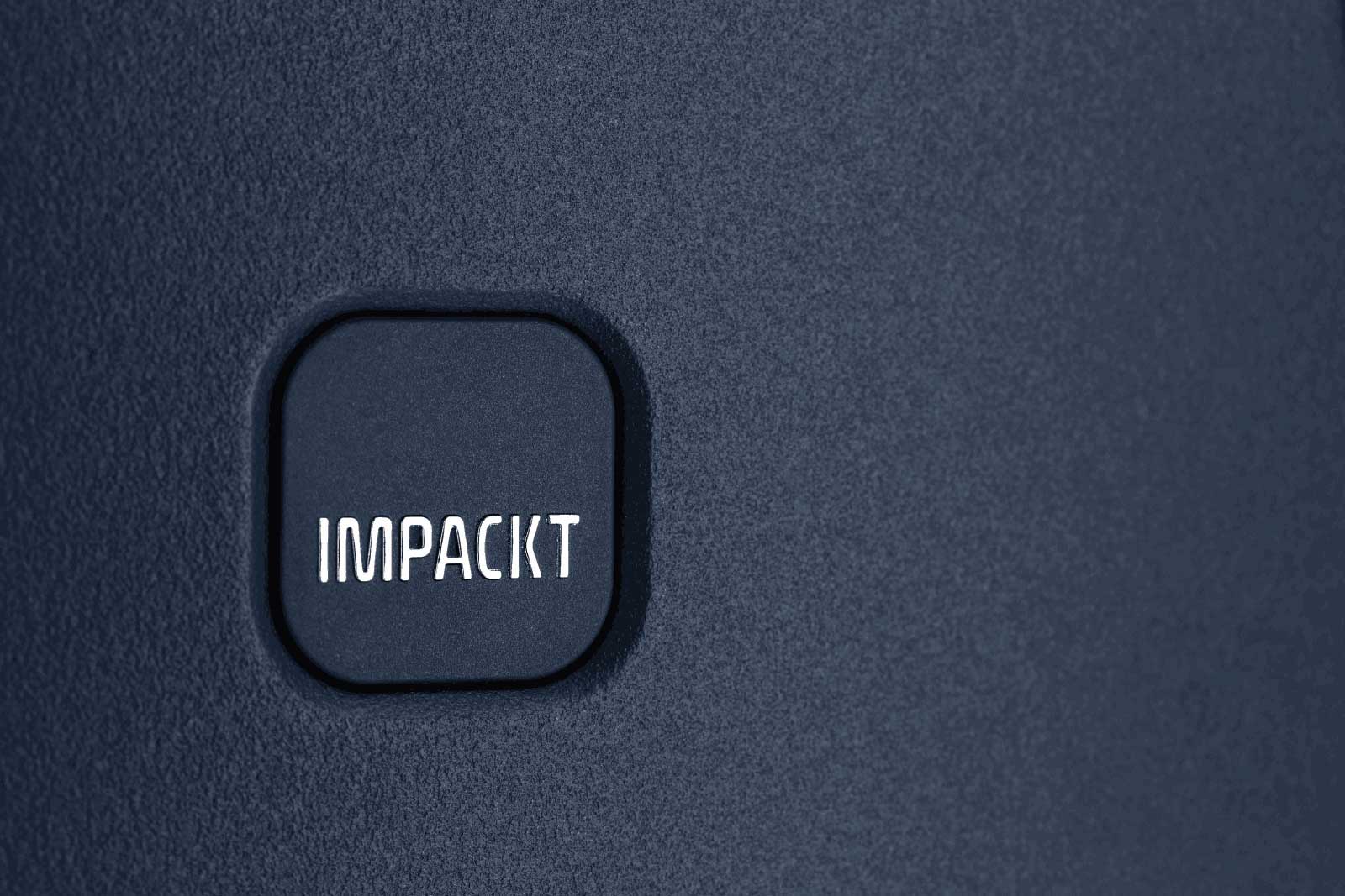 Nahaufnahme einer strukturierten blauen Oberfläche mit IMPACKT-Logo Blaues rechteckiges Logo mit der Aufschrift IMPACKT auf strukturierter Oberfläche