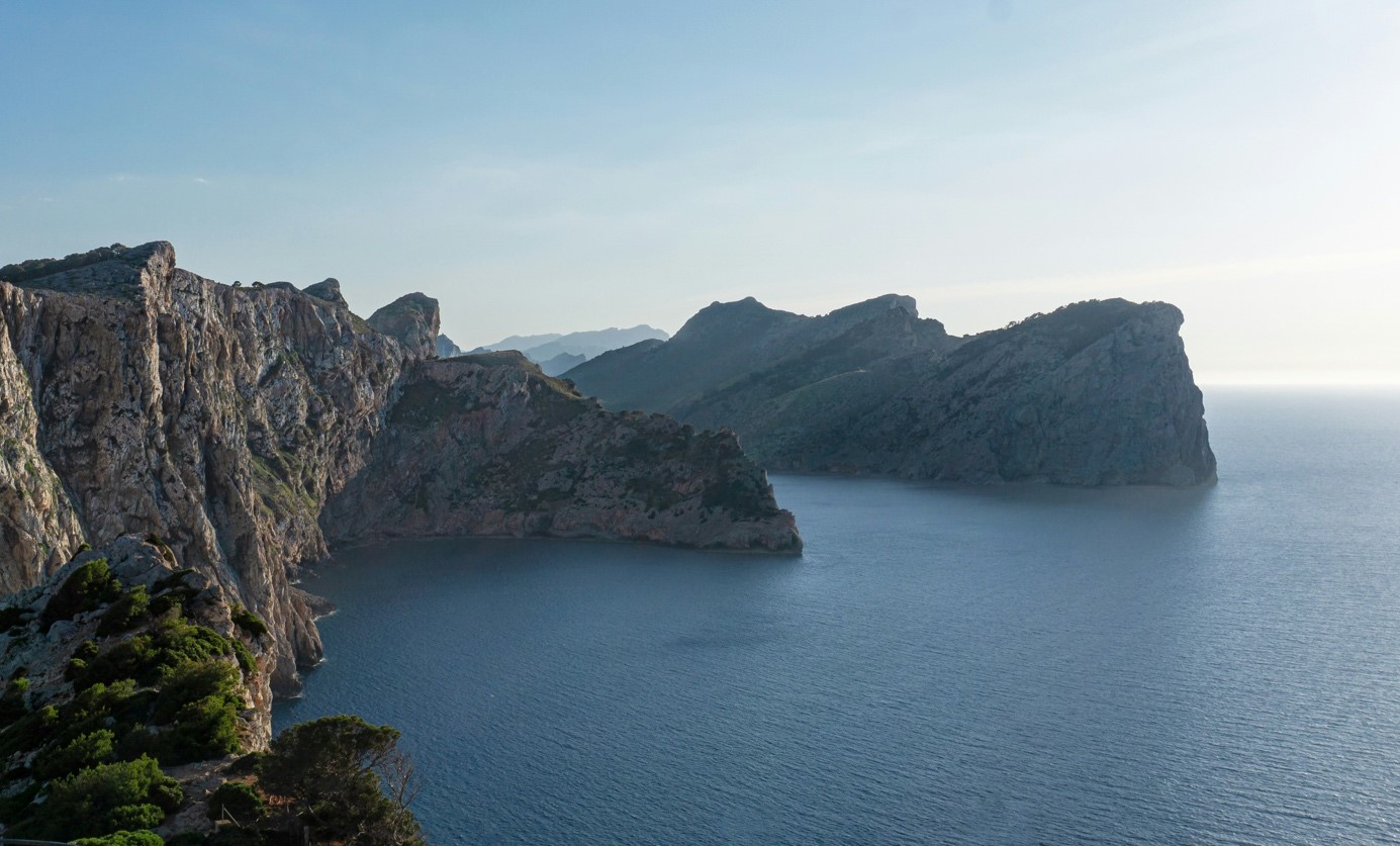 Nachhaltiger auf Mallorca: Restaurants, Hotels & Aktivitäten Küstenlandschaft mit hohen Felsen und ruhigem Meer bei Tageslicht